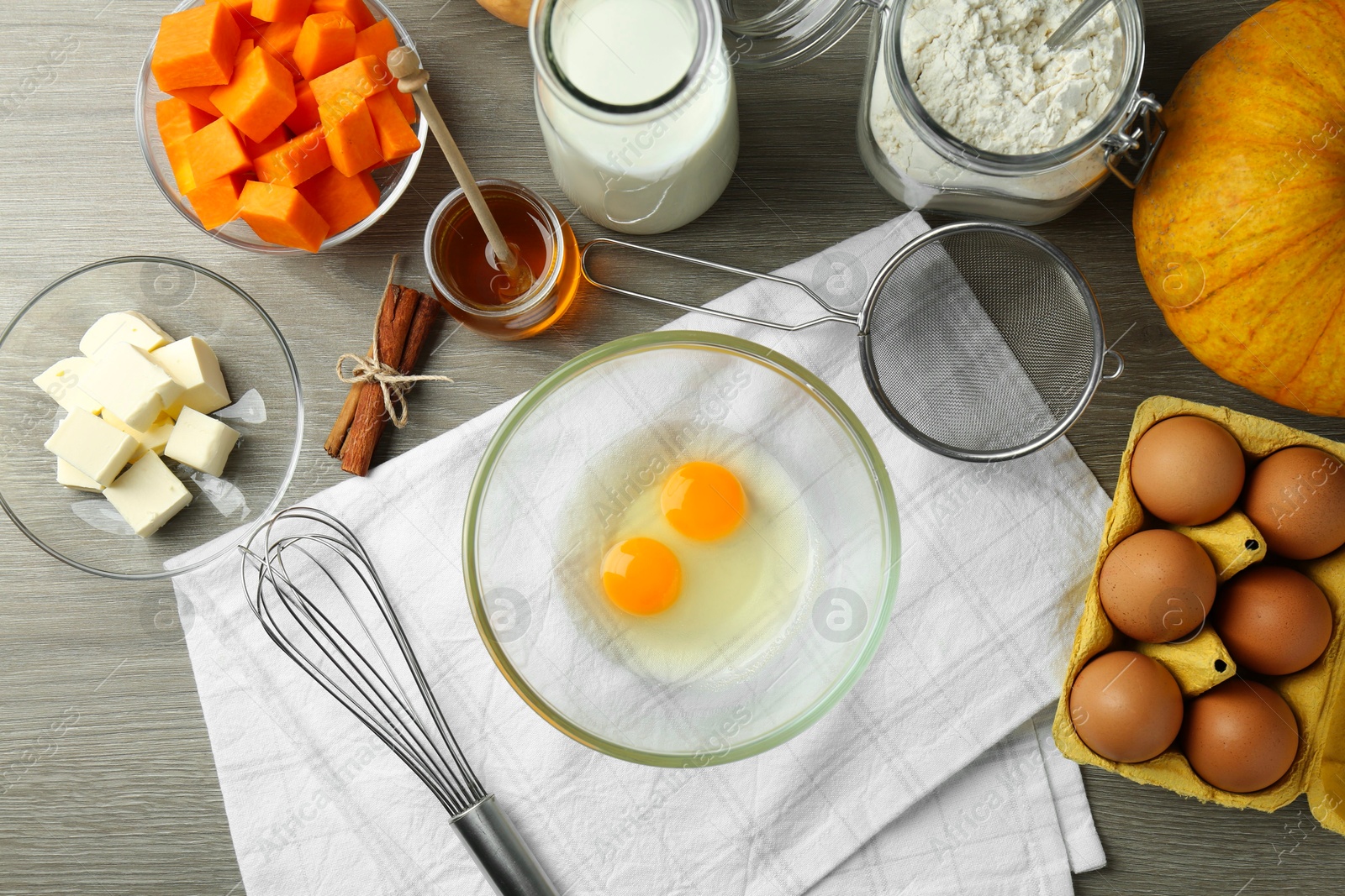 Photo of Different ingredients for pumpkin pancakes on wooden table, flat lay