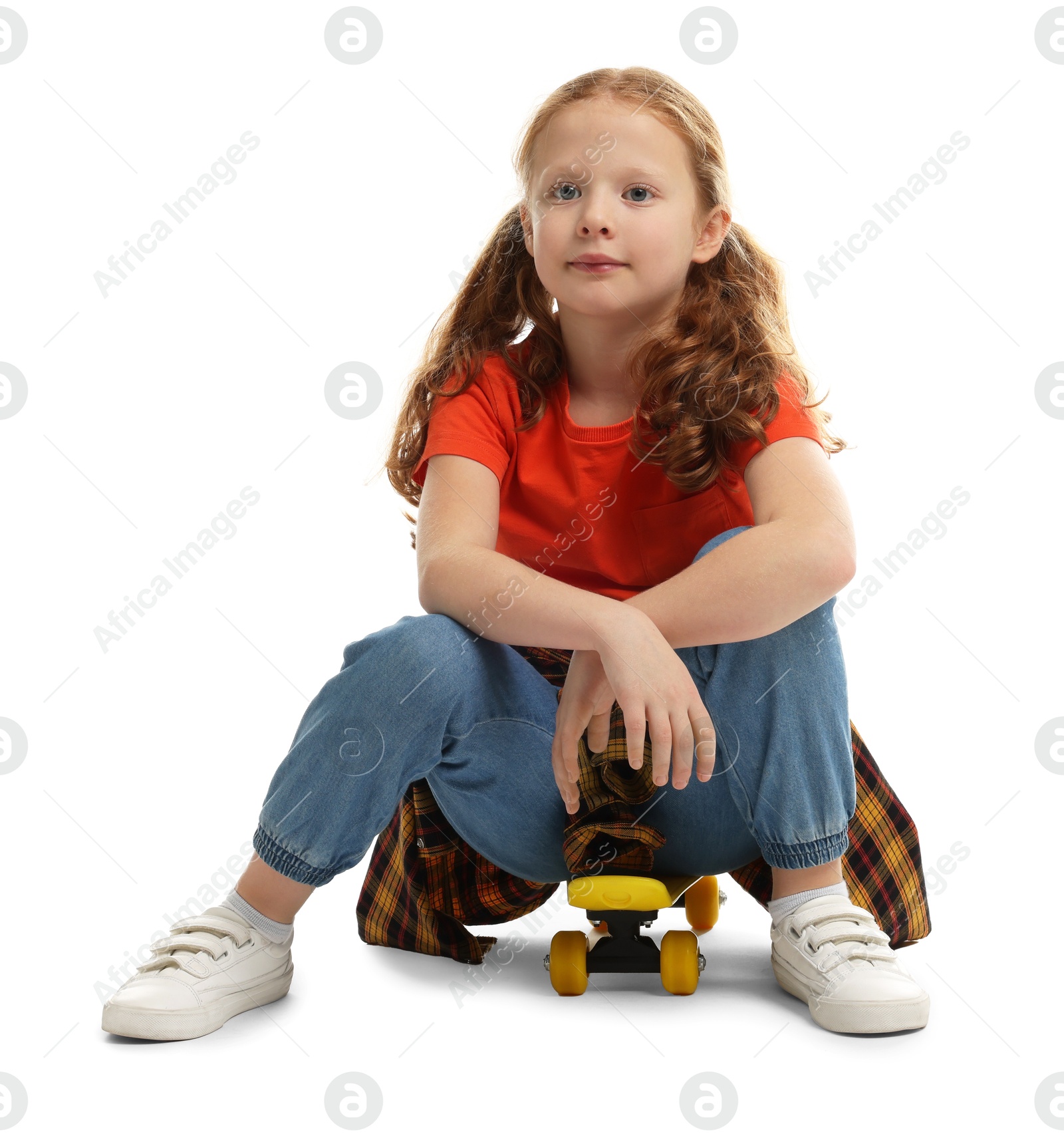 Photo of Stylish little girl sitting on penny board against white background