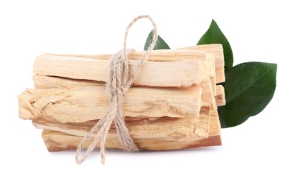 Photo of Bunch of palo santo sticks and green leaves on white background