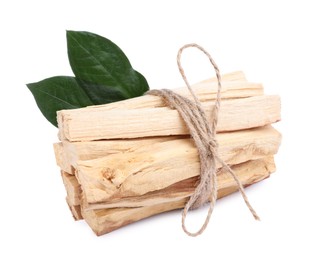 Photo of Bunch of palo santo sticks and green leaves on white background