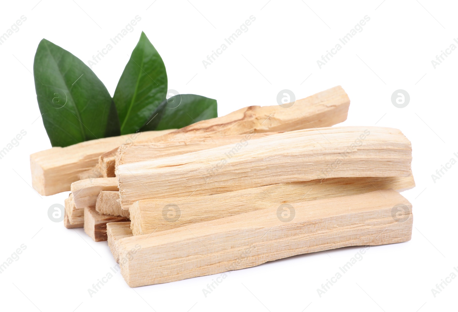 Photo of Pile of palo santo sticks and green leaves on white background