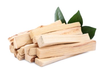 Photo of Pile of palo santo sticks and green leaves on white background