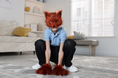 Photo of Quadrobics. Boy wearing fox mask and gloves at home