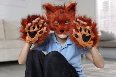 Quadrobics. Boy wearing fox mask and gloves at home