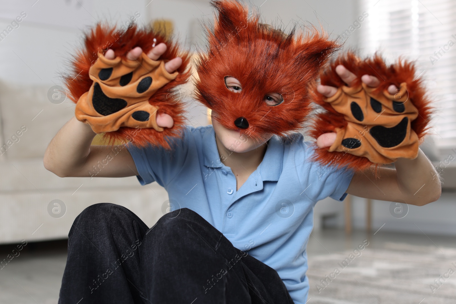 Photo of Quadrobics. Boy wearing fox mask and gloves at home