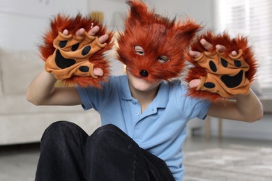 Photo of Quadrobics. Boy wearing fox mask and gloves at home