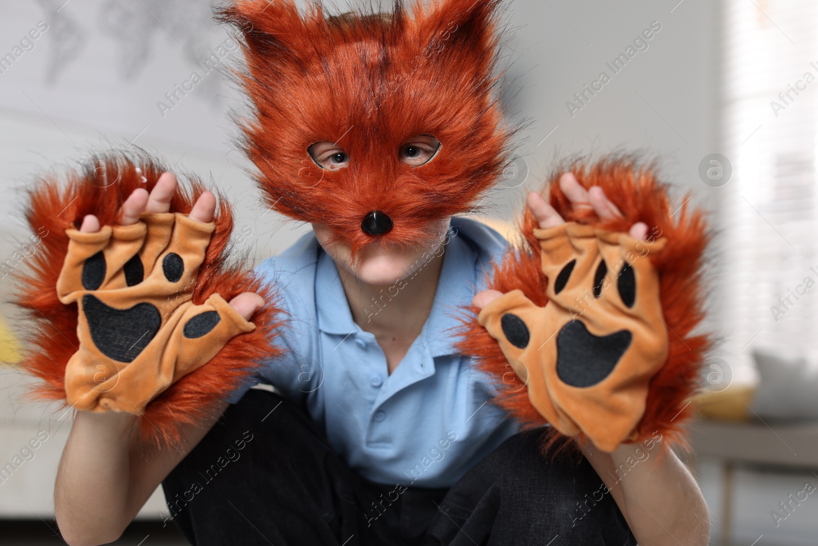 Photo of Quadrobics. Boy wearing fox mask and gloves at home