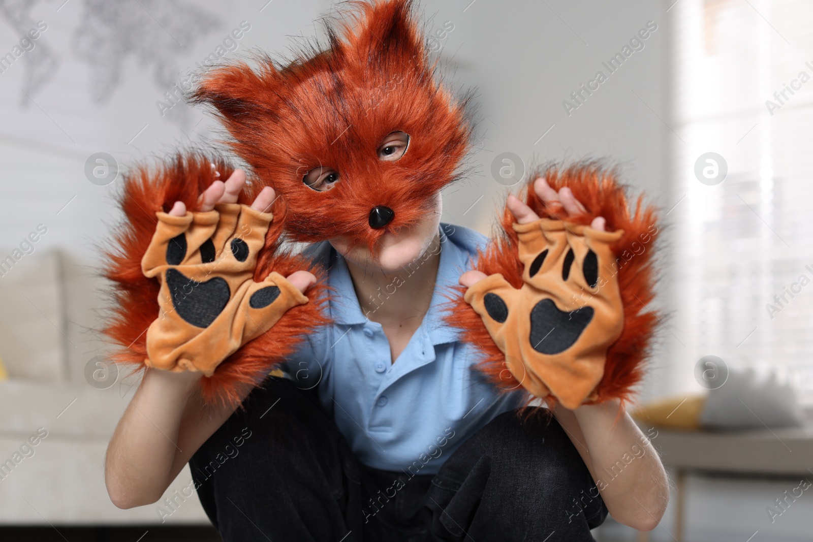 Photo of Quadrobics. Boy wearing fox mask and gloves at home