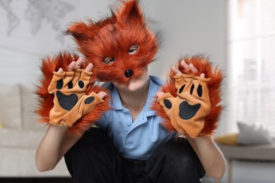 Photo of Quadrobics. Boy wearing fox mask and gloves at home