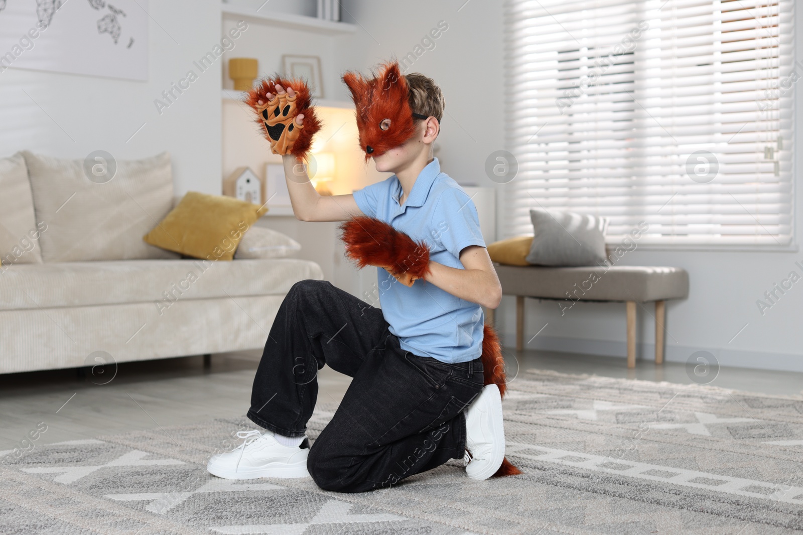 Photo of Quadrobics. Boy wearing fox mask, tail and gloves at home