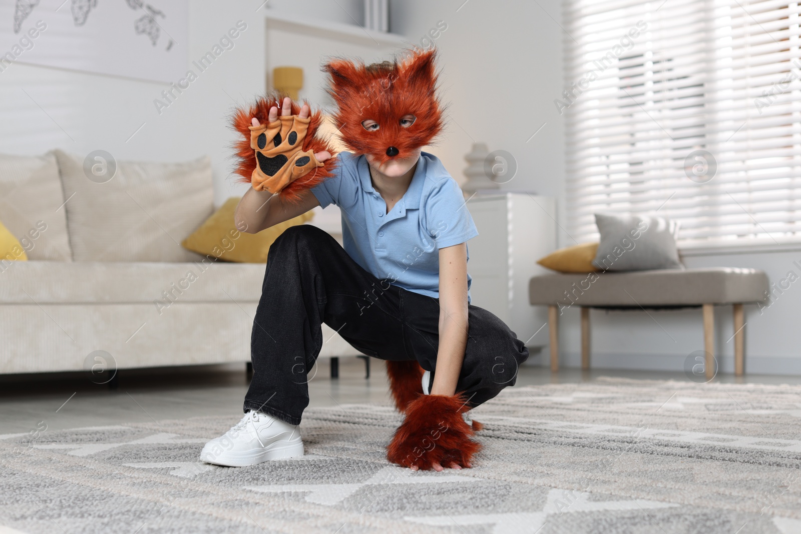 Photo of Quadrobics. Boy wearing fox mask, tail and gloves at home