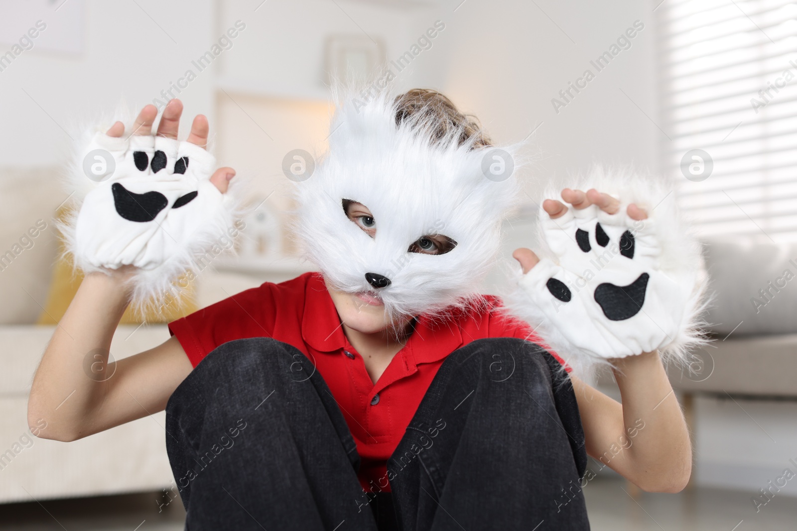 Photo of Quadrobics. Boy wearing cat mask and gloves at home