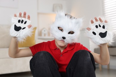 Photo of Quadrobics. Boy wearing cat mask and gloves at home