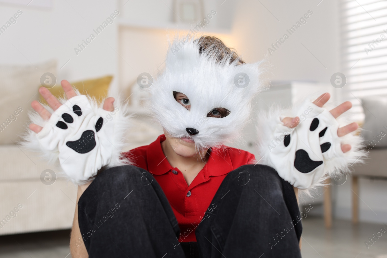 Photo of Quadrobics. Boy wearing cat mask and gloves at home