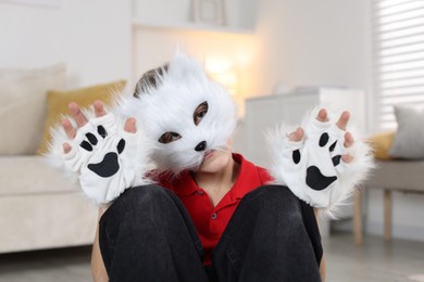 Photo of Quadrobics. Boy wearing cat mask and gloves at home