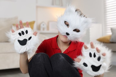 Photo of Quadrobics. Boy wearing cat mask and gloves at home