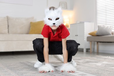 Photo of Quadrobics. Boy wearing cat mask and gloves at home