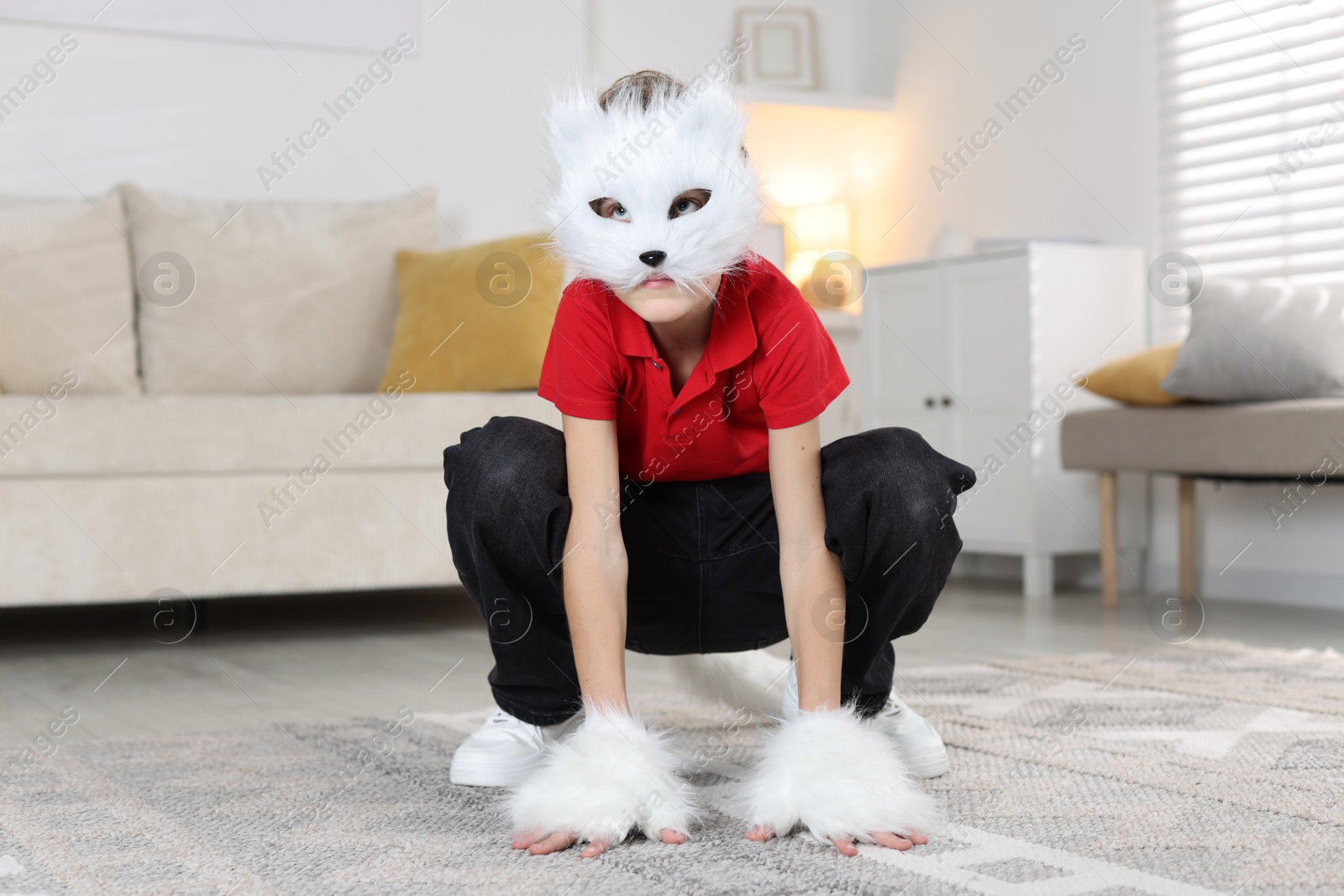 Photo of Quadrobics. Boy wearing cat mask and gloves at home