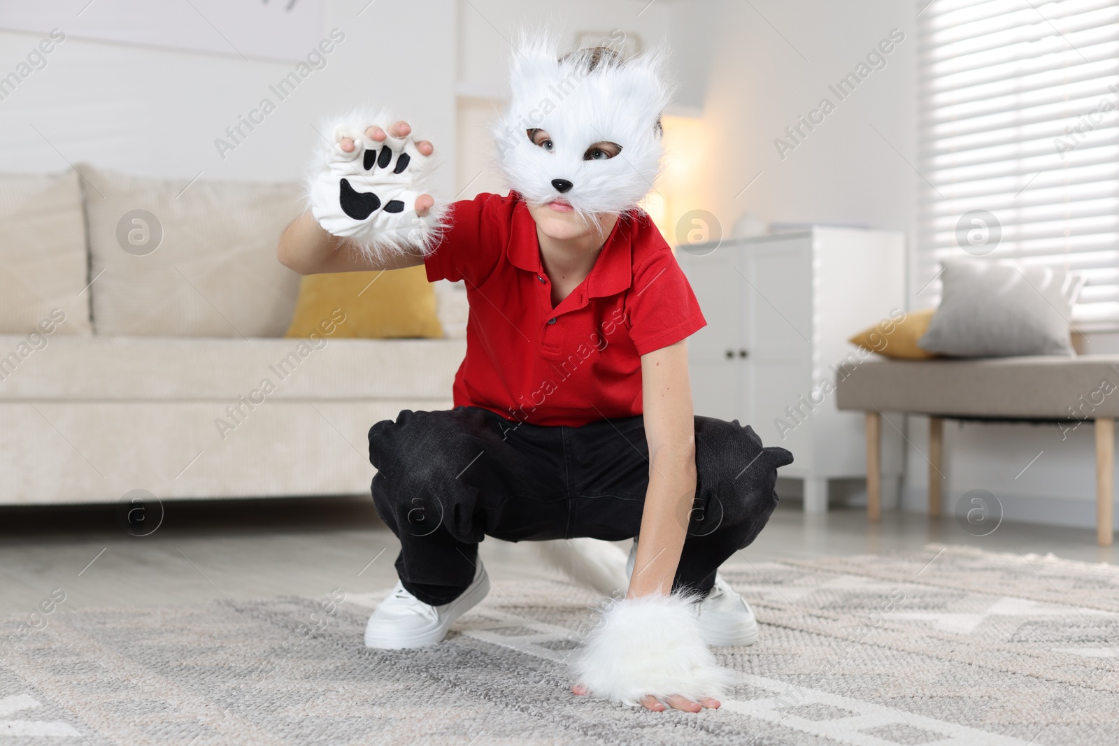 Photo of Quadrobics. Boy wearing cat mask and gloves at home