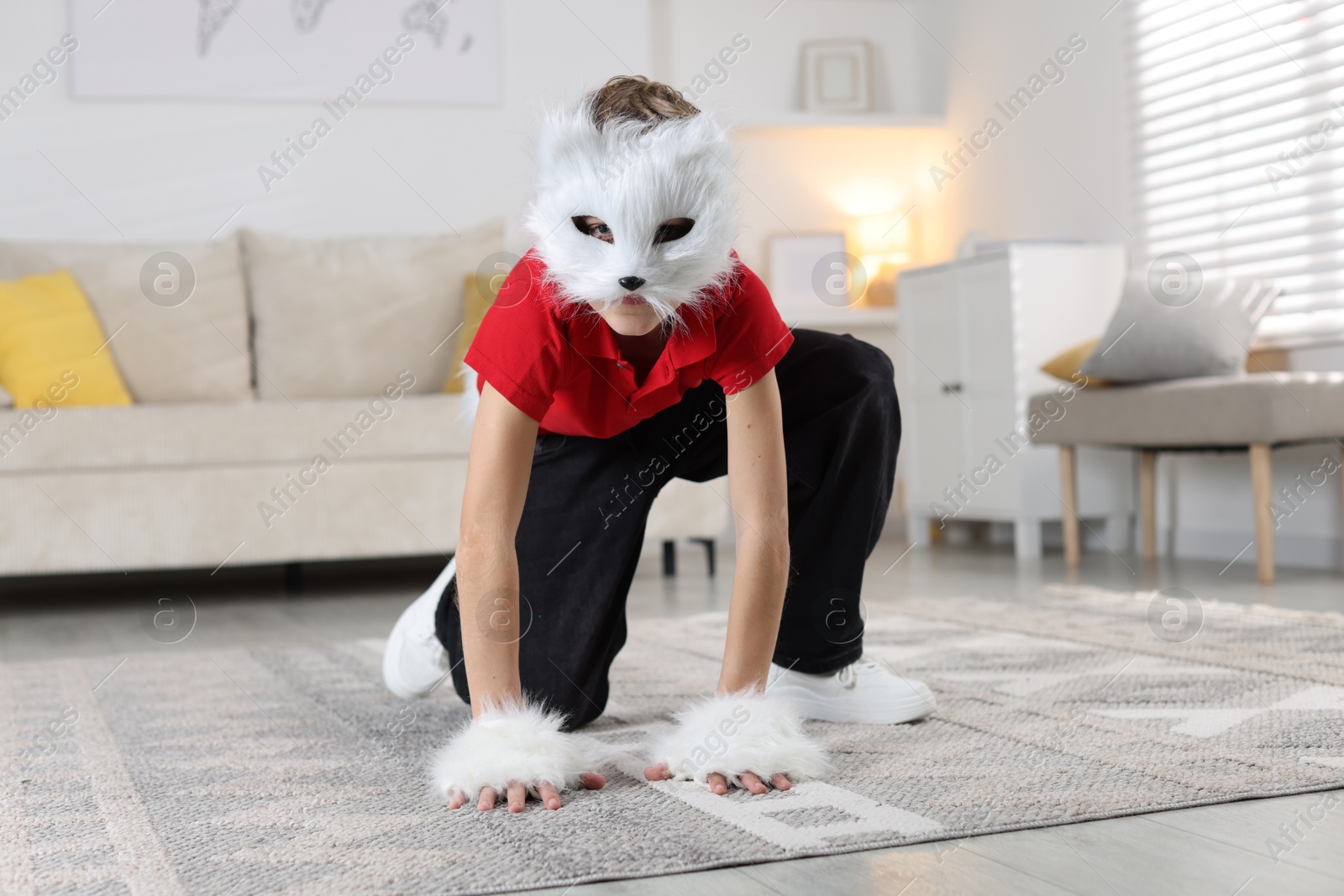 Photo of Quadrobics. Boy wearing cat mask and gloves at home