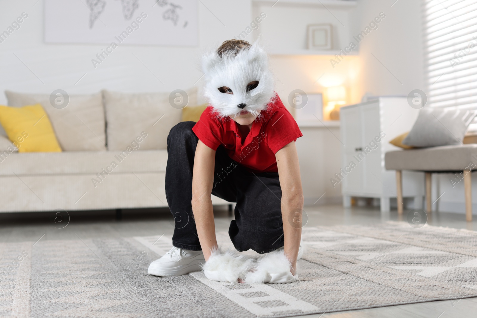 Photo of Quadrobics. Boy wearing cat mask and gloves at home