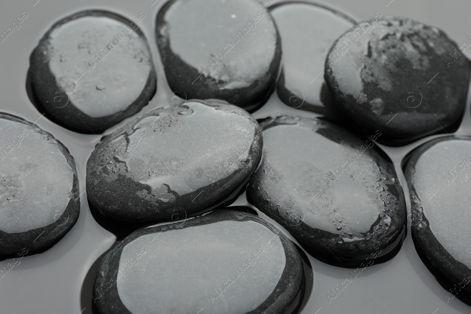 Photo of Many spa stones on water surface, closeup