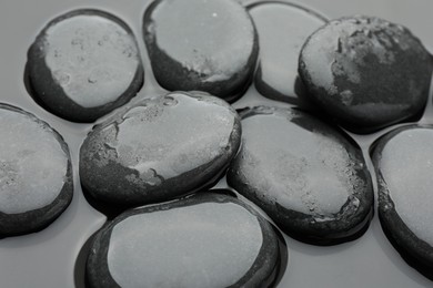 Photo of Many spa stones on water surface, closeup