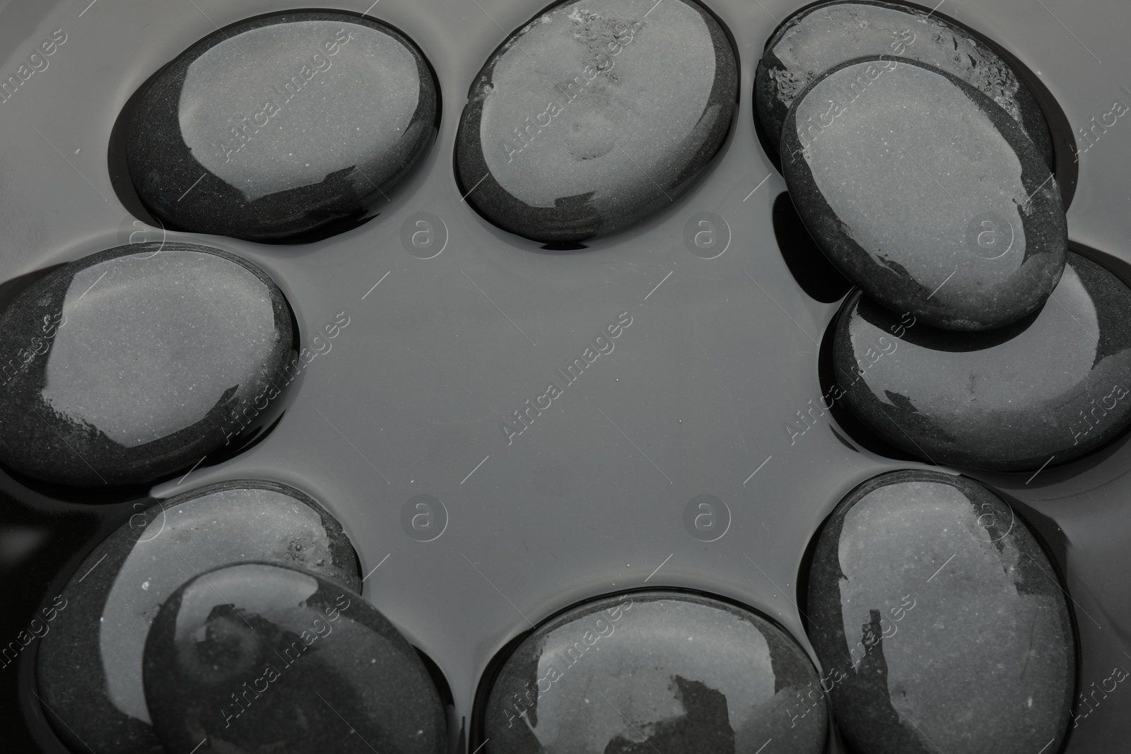 Photo of Frame of spa stones on water surface, flat lay. Space for text