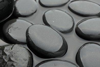 Photo of Many spa stones in water, closeup view