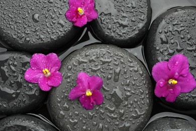 Photo of Spa stones and flowers on water surface, top view