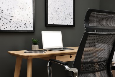 Photo of Comfortable workplace with modern laptop on wooden table indoors