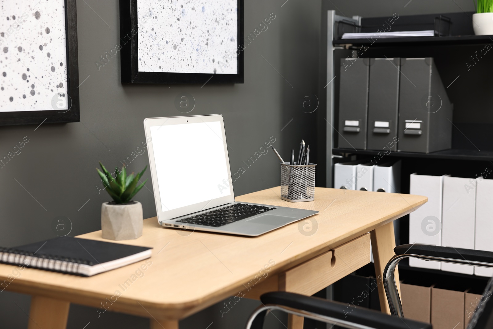 Photo of Comfortable workplace with modern laptop on wooden table indoors