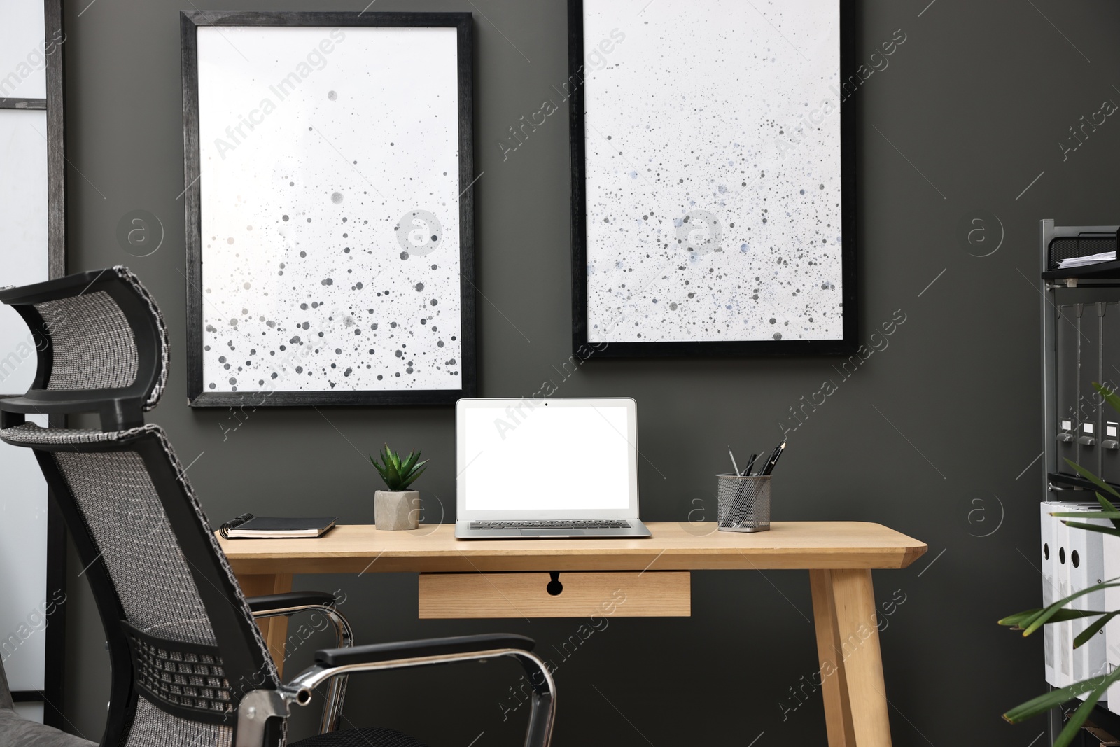 Photo of Comfortable workplace with modern laptop on wooden table indoors