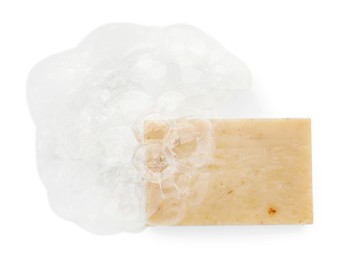 Photo of Beige soap with foam on white background, top view