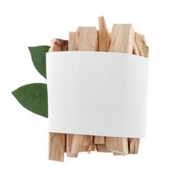 Palo santo sticks wrapped in paper and green leaves on white background