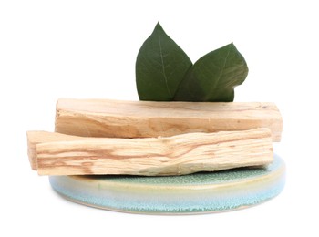 Photo of Palo santo sticks and green leaves on white background