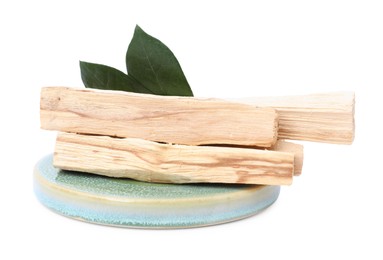 Palo santo sticks and green leaves on white background