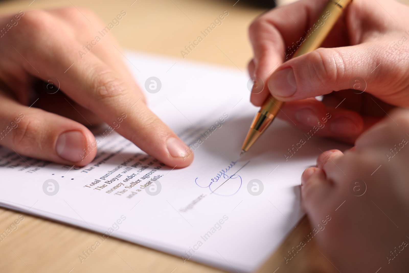 Photo of Man pointing at document and woman putting signature at table, closeup