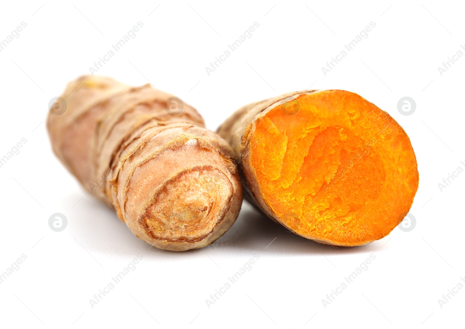 Photo of Whole and cut turmeric roots isolated on white