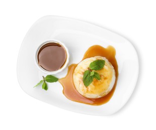 Photo of Tasty pudding with caramel sauce and mint isolated on white, top view