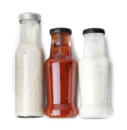 Photo of Different delicious sauces in glass bottles isolated on white, top view