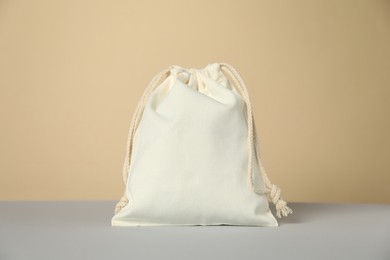 Photo of One cotton bag on grey table against beige background