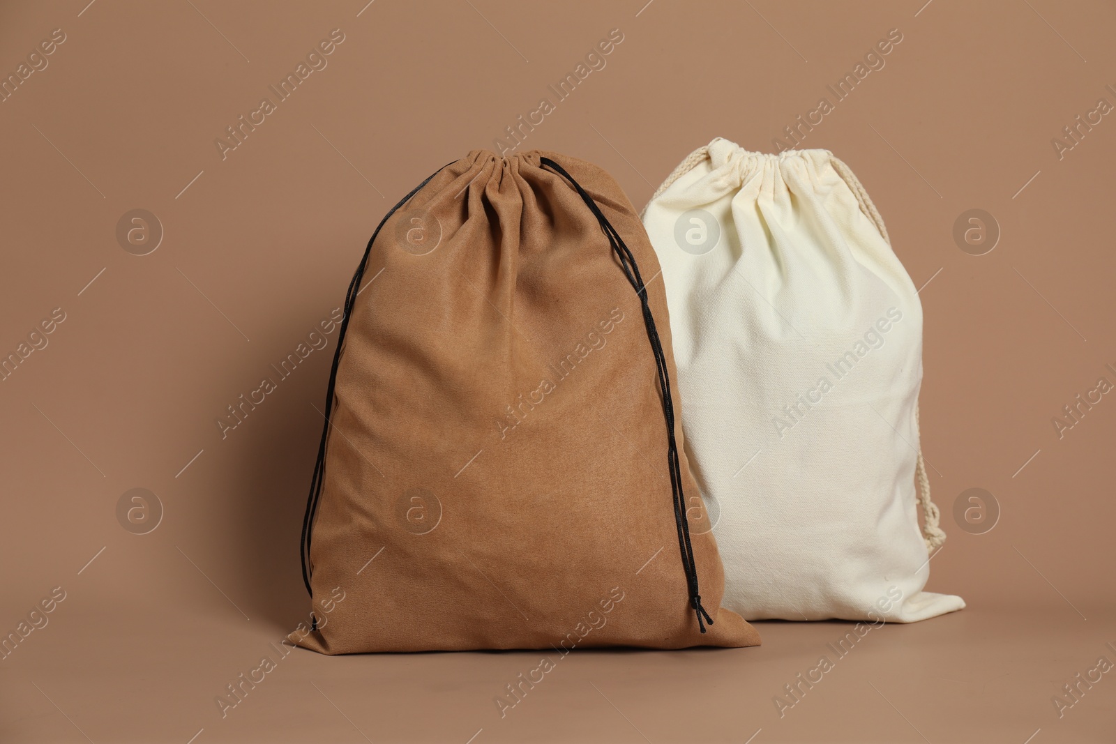 Photo of Two cotton bags on dark beige background