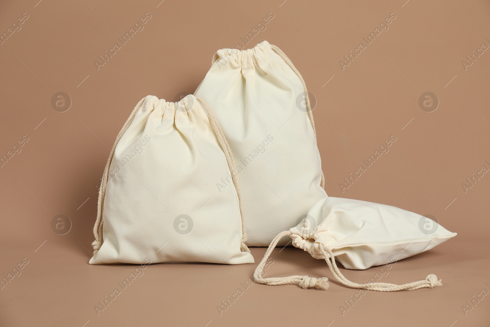 Photo of Different cotton bags on dark beige background