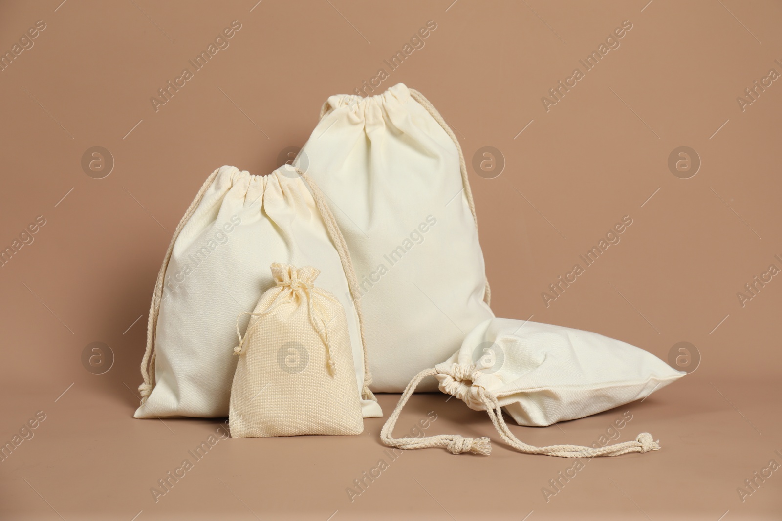 Photo of Burlap and cotton bags on dark beige background