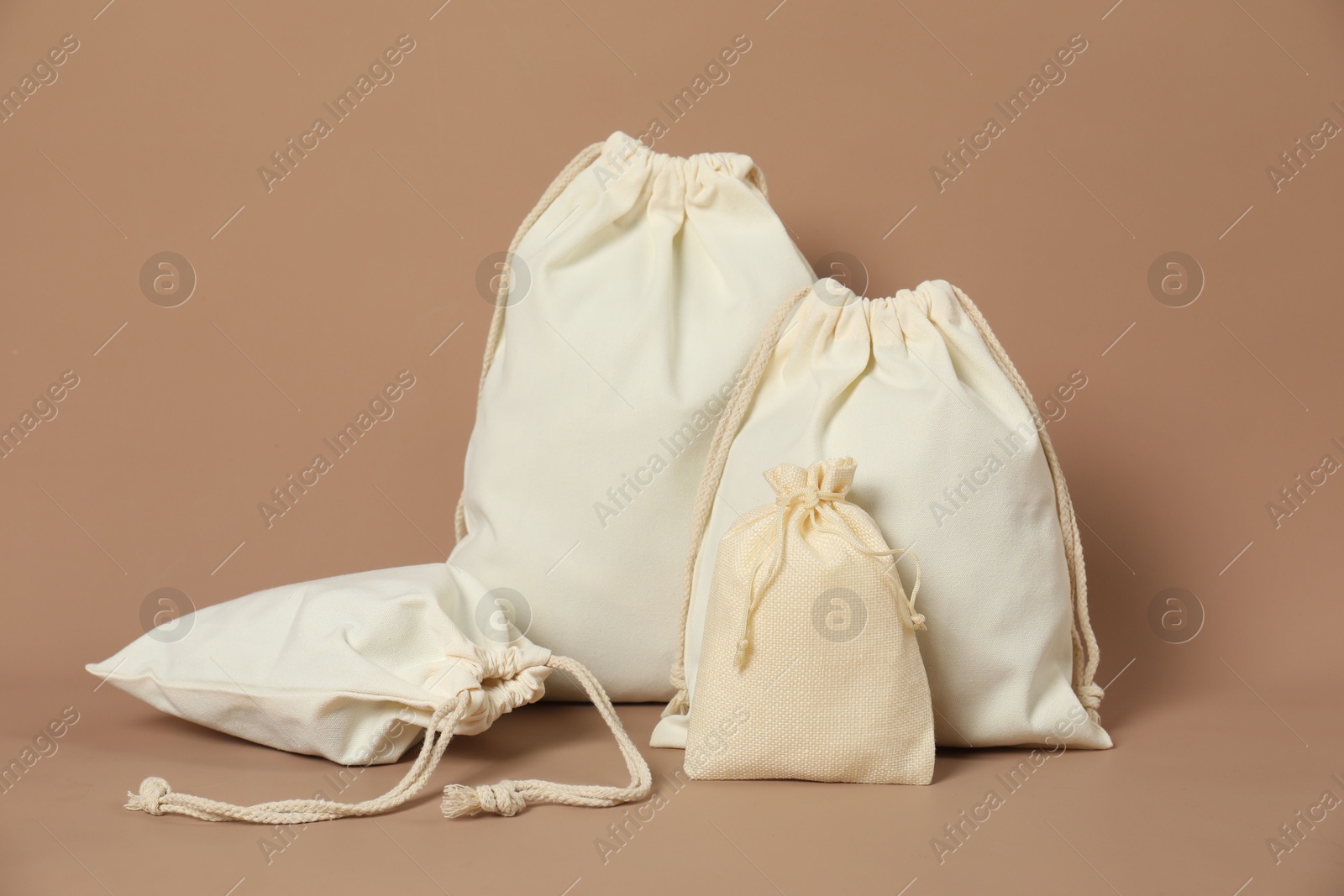 Photo of Burlap and cotton bags on dark beige background