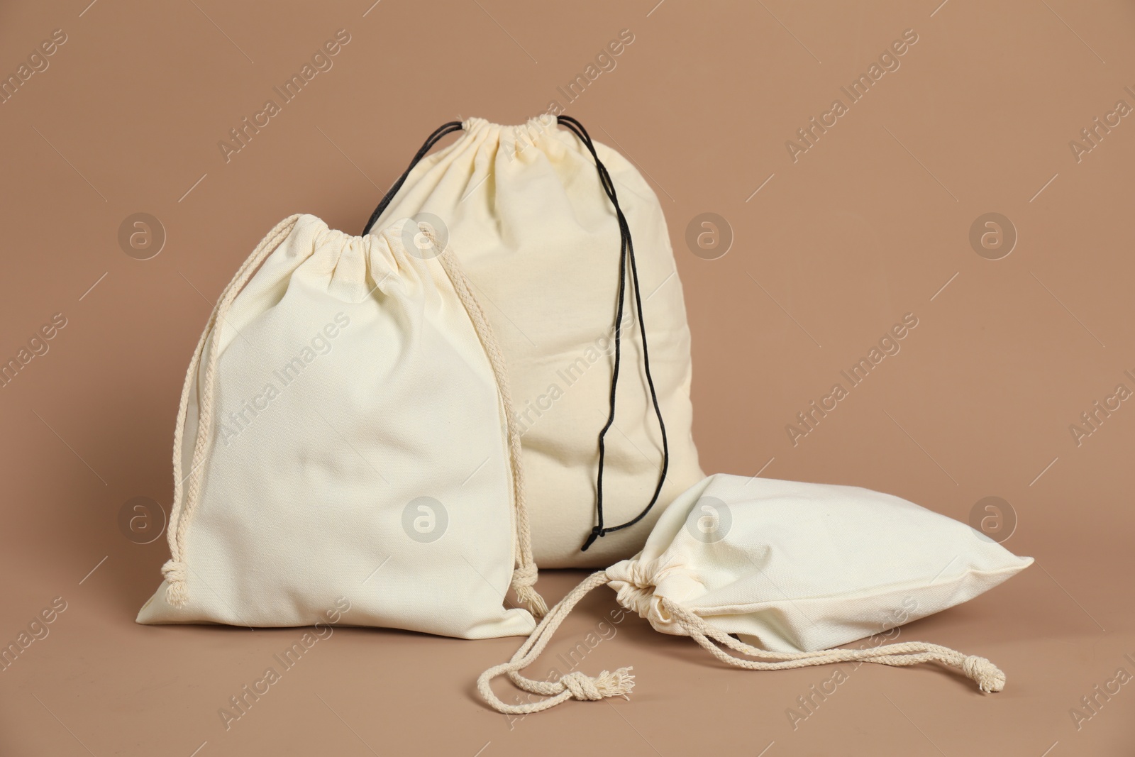 Photo of Different cotton bags on dark beige background