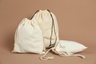 Photo of Different cotton bags on dark beige background