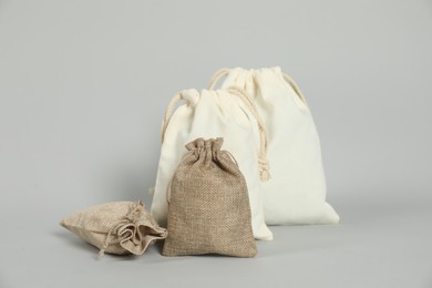 Photo of Burlap and cotton bags on grey background