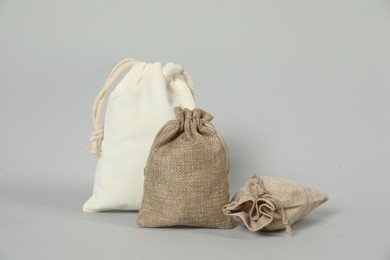 Photo of Burlap and cotton bags on grey background